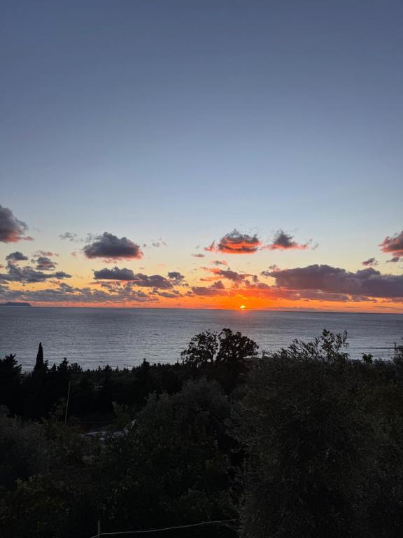 a sunset over the ocean with the sun in the sky at Ionian Sunset Drymades in Gjilek