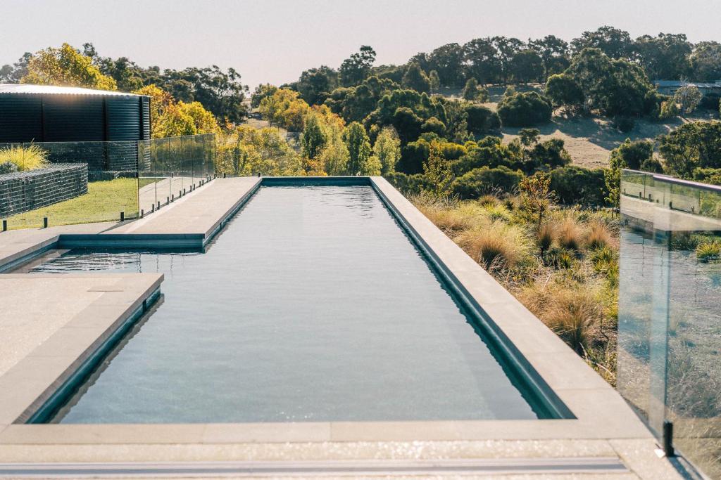 a swimming pool on the side of a house at The Valley Lodge in Yallingup