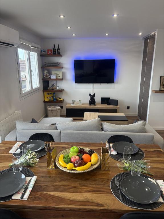a living room with a table with a bowl of fruit at T2 design climatisé au coeur de Divonne in Divonne-les-Bains