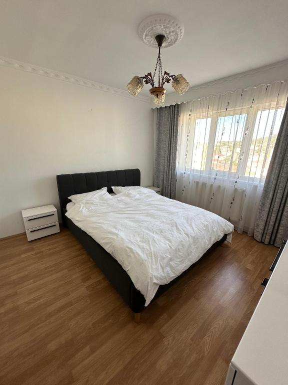 a bedroom with a bed and a chandelier at Perla Central Apartment in Zalău