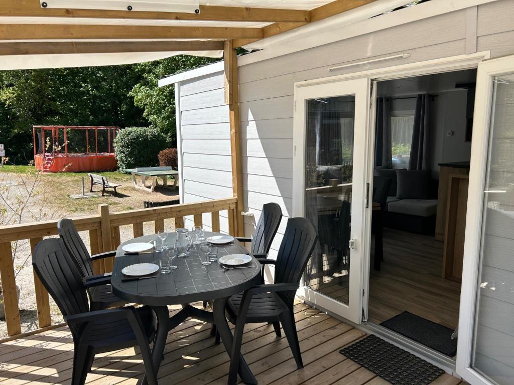 a patio with a table and chairs on a deck at Camping de Contrexeville in Contrexéville