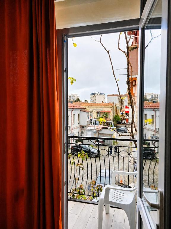 a balcony with a white chair and a view of a city at Smash Hostel Batumi in Batumi