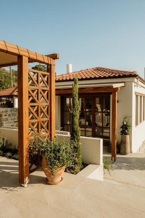 a wooden pergola in front of a house at Galetso Studios by Still Collection in Nikiti