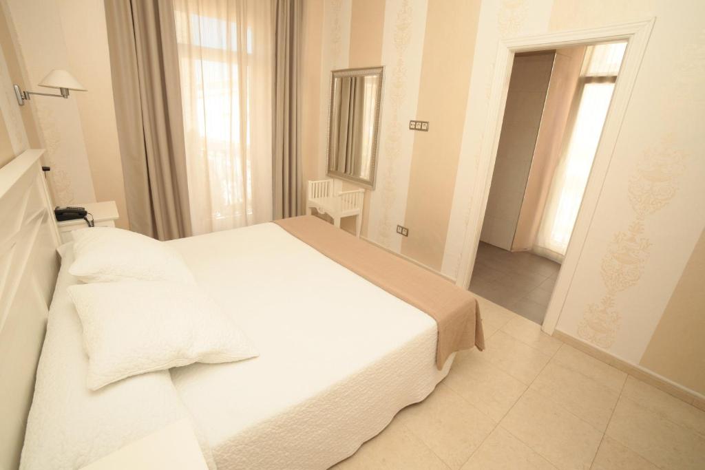 a white bedroom with a white bed in a room at Convento Tarifa in Tarifa