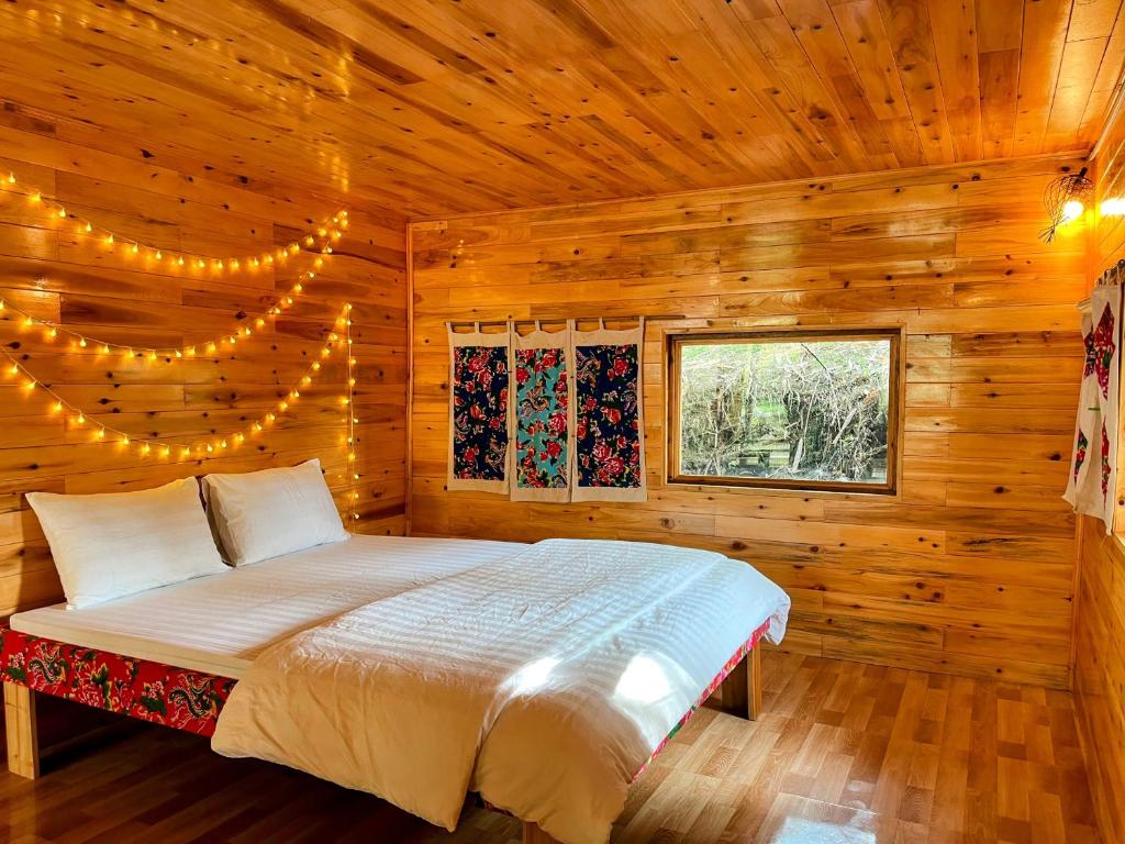 a bedroom with a bed in a wooden cabin at The Happy Cozy Corner! in Lao Cai