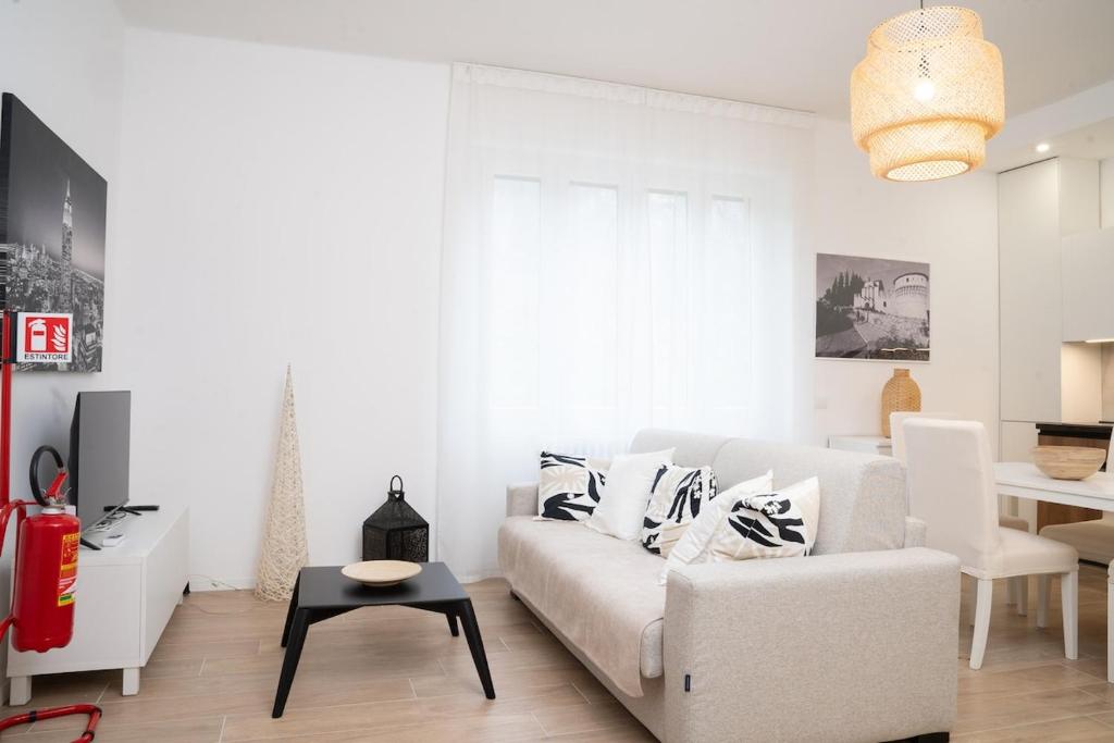 a living room with a white couch and a table at The Castle Apartment in Brescia