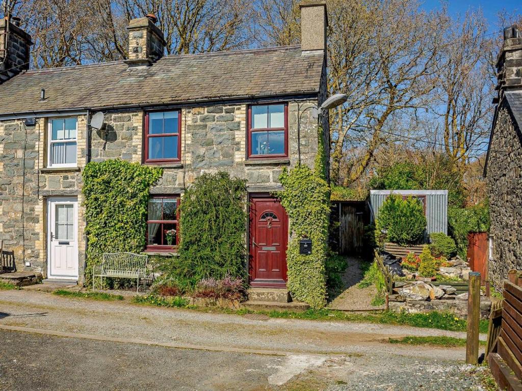 a stone house with a red door at 2 Bed in Blaenau Ffestiniog oc-86064 in Maentwrog