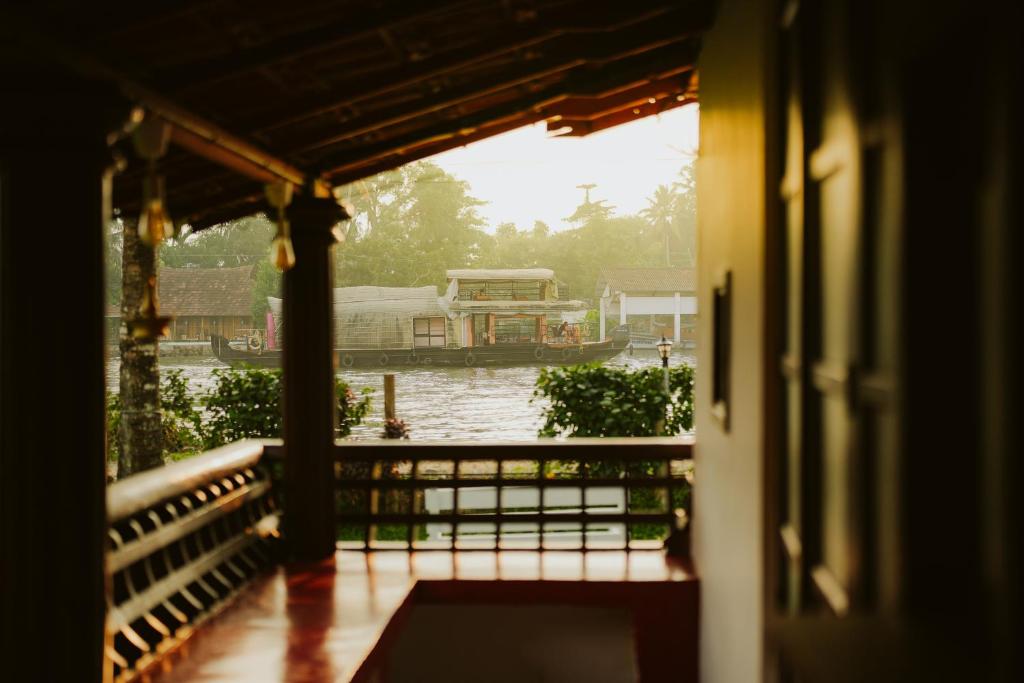 a house with a view of a boat in the water at Alleppey Backwater Resort in Alleppey