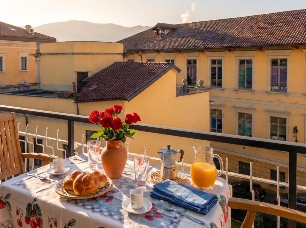 a table with food and flowers on a balcony at Casa Niky in Verbania