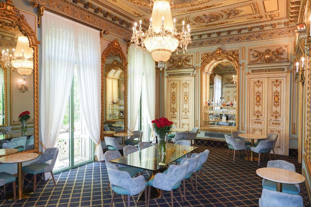 a dining room with a table and chairs and a chandelier at Hotel Continental Palacete in Barcelona