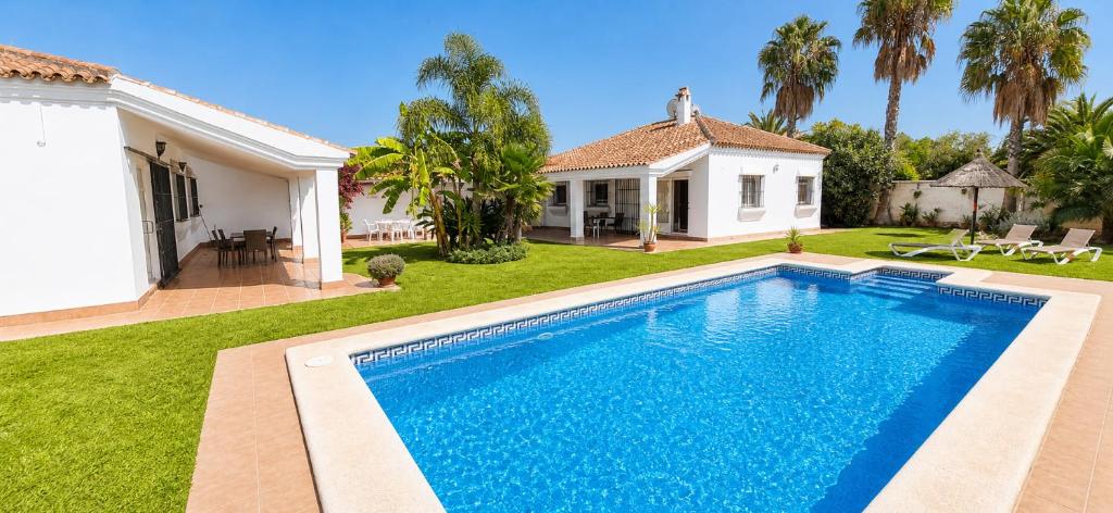 a swimming pool in the yard of a house at Andalusian patio villa 12 pax with private pool in Conil de la Frontera