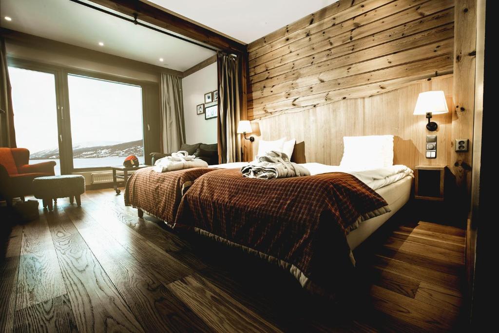 um quarto com uma cama e uma parede de madeira em Holiday Club Åre em Åre