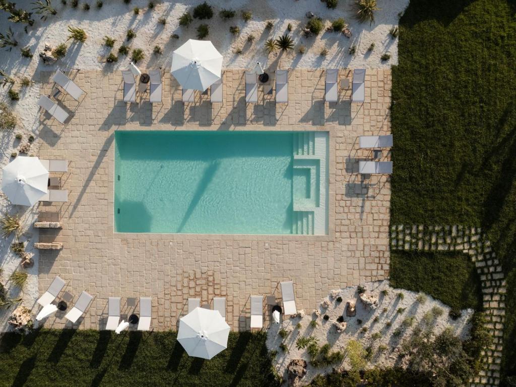 an overhead view of a pool with chairs and umbrellas at Masseria Macchiaforte in Gallipoli