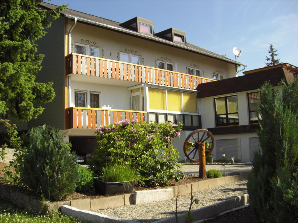 una casa con un balcón en el lateral. en Pension Zum Köhler en Schönwald