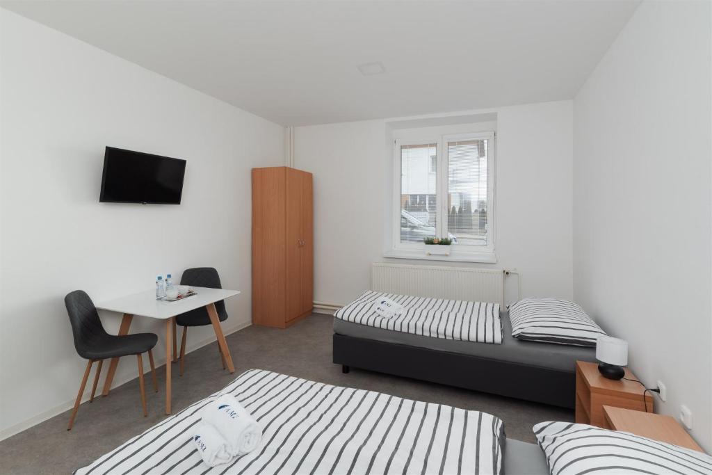 a bedroom with a bed and a desk and a table at Ubytování AMZ in Vrábí
