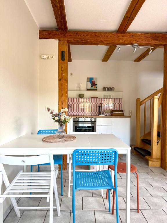 a kitchen with a white table and blue chairs at Familienbett und Sauna - Muschelbude in Wittenbeck