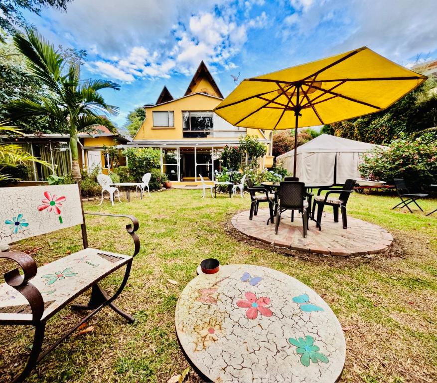 a patio with chairs and a table with an umbrella at Hotel Casa Iris in Chía