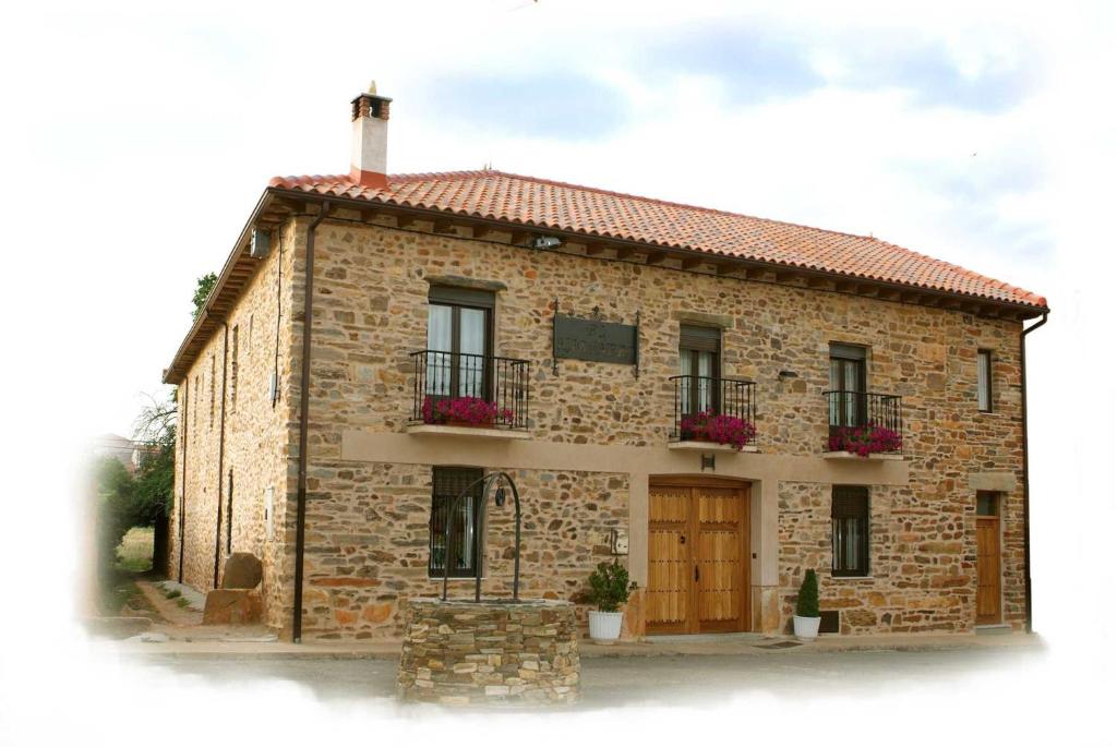 a brick building with two balconies and a door at Hotel Rural El Habanero in Destriana