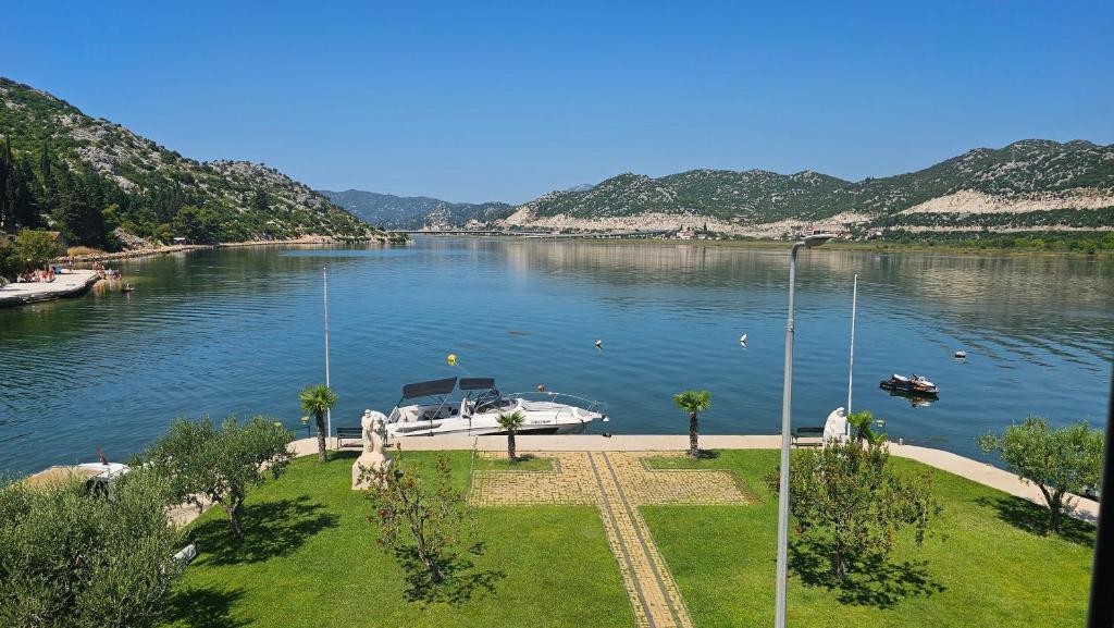a boat is docked on a river with mountains at Haven Bay Apartment in Rogotin