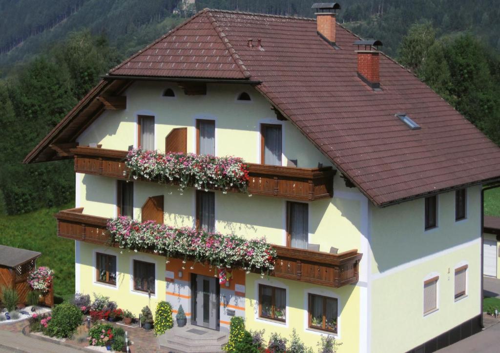 ein Haus mit Blumen auf der Seite in der Unterkunft Frühstückspension Kuzmic in Wartberg