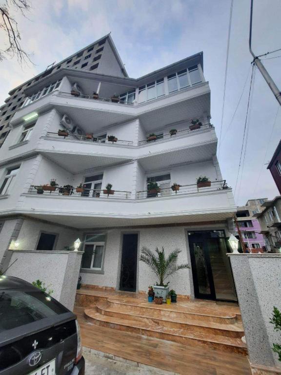 a white house with wooden steps in front of it at Hotel Tabidze in Batumi