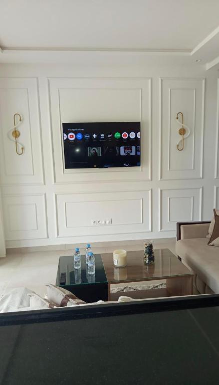 a living room with a couch and a tv on a wall at Appartement suite in Cabo Negro