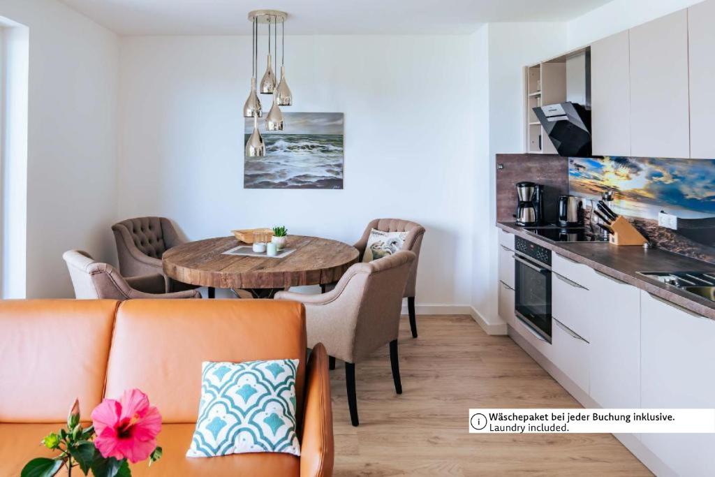 a living room with a table and a kitchen at Zweite Heimat Apartment 2 in Lohme