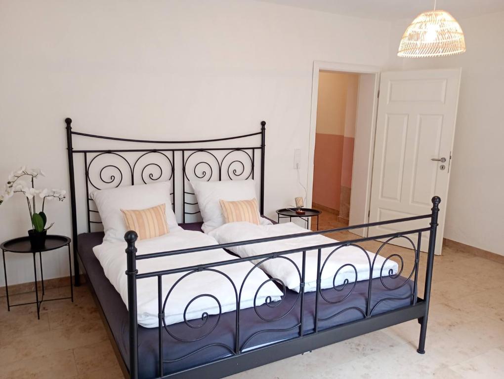 a bedroom with a black bed with white sheets and pillows at Cottage Living 2 in Leiblfing