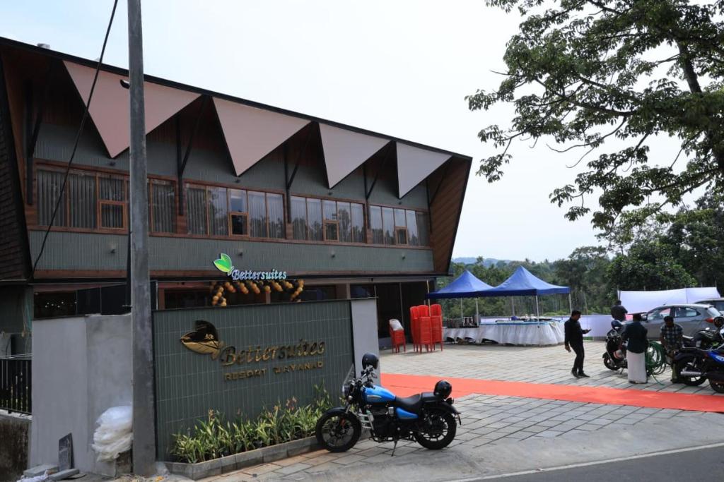a motorcycle parked in front of a building at Better Suites Hotel in Meppādi