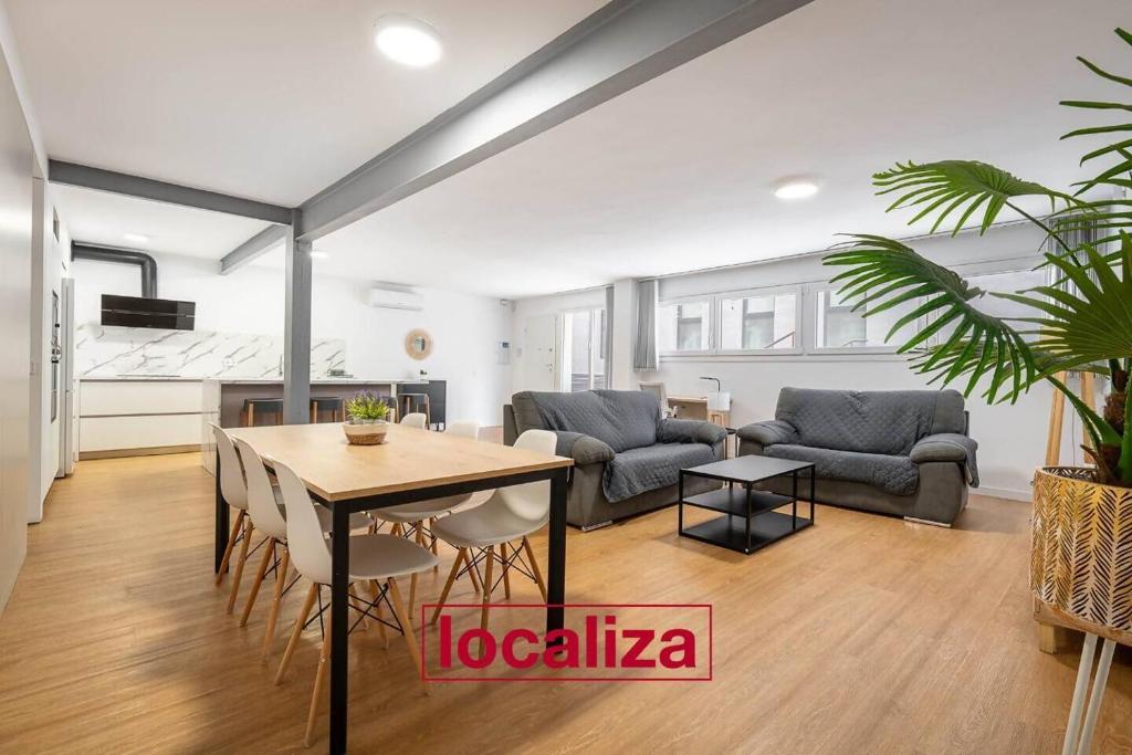 a living room with a table and a couch at Amplio y moderno apartamento in Almería