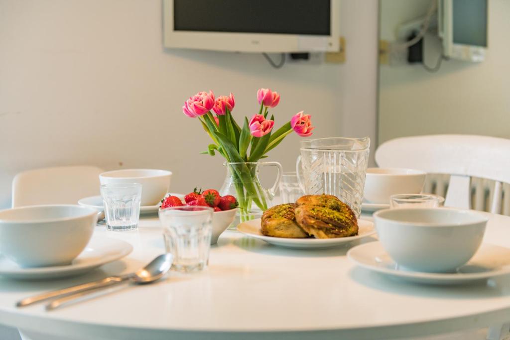 a table with plates of food and flowers on it at Captains Cottage in Deal