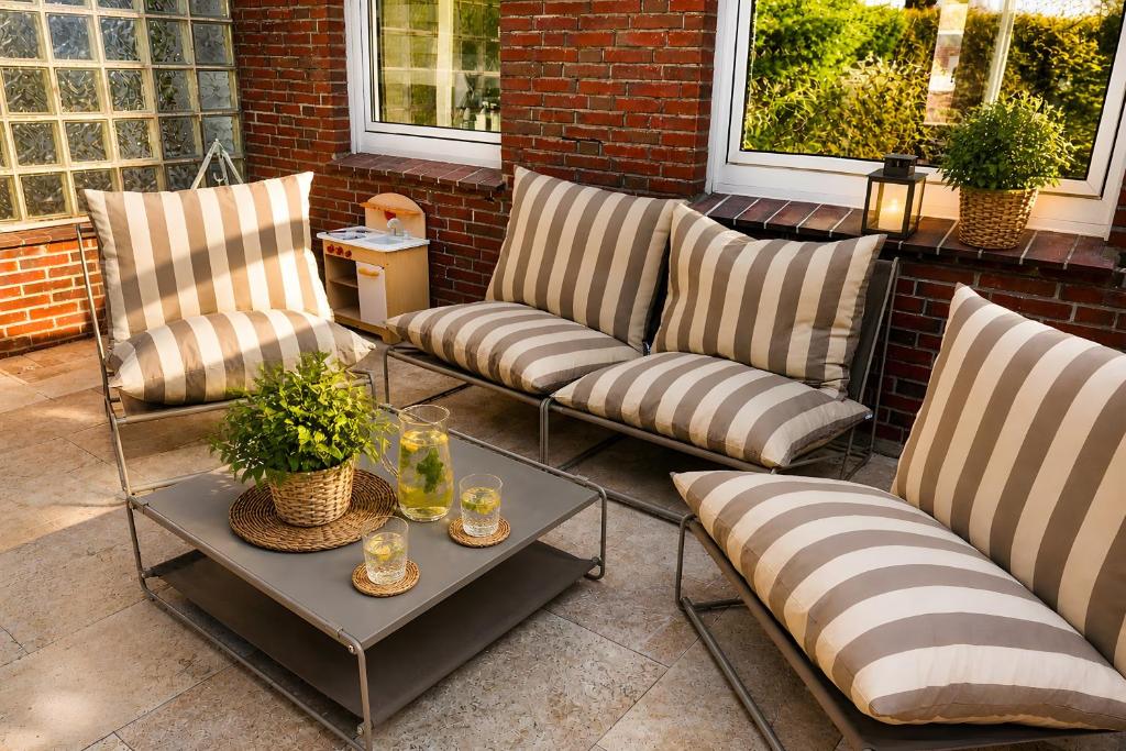 three chairs and a table on a patio at Buddelhuus in Norddeich