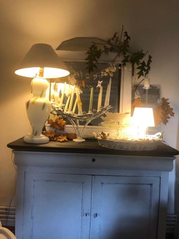 a lamp and a mirror on top of a cabinet at Le presbytère in Le Crouais