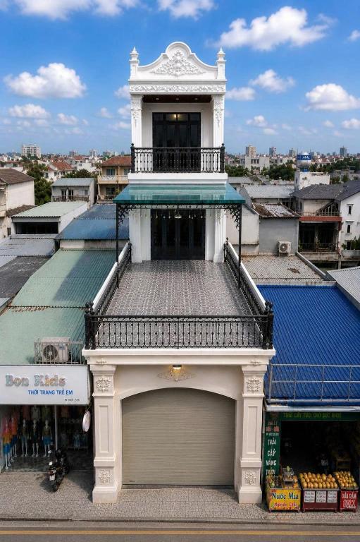 a white building with a balcony on top of a building at Willow Stay in Hai Phong