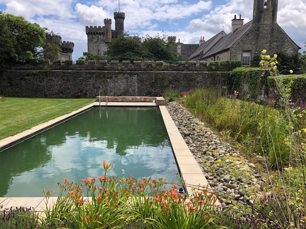 a pool in a garden with a castle in the background at Garden House Barmeath Castle in Grangebellew