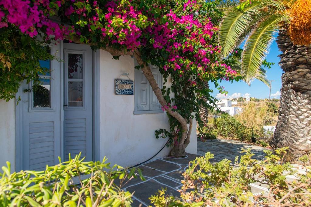 a white house with pink flowers on it at Niokratis in Áno Petálion