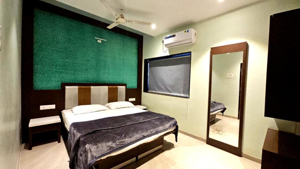 a bedroom with a bed and a large mirror at Vardhan Lodge in Ajra