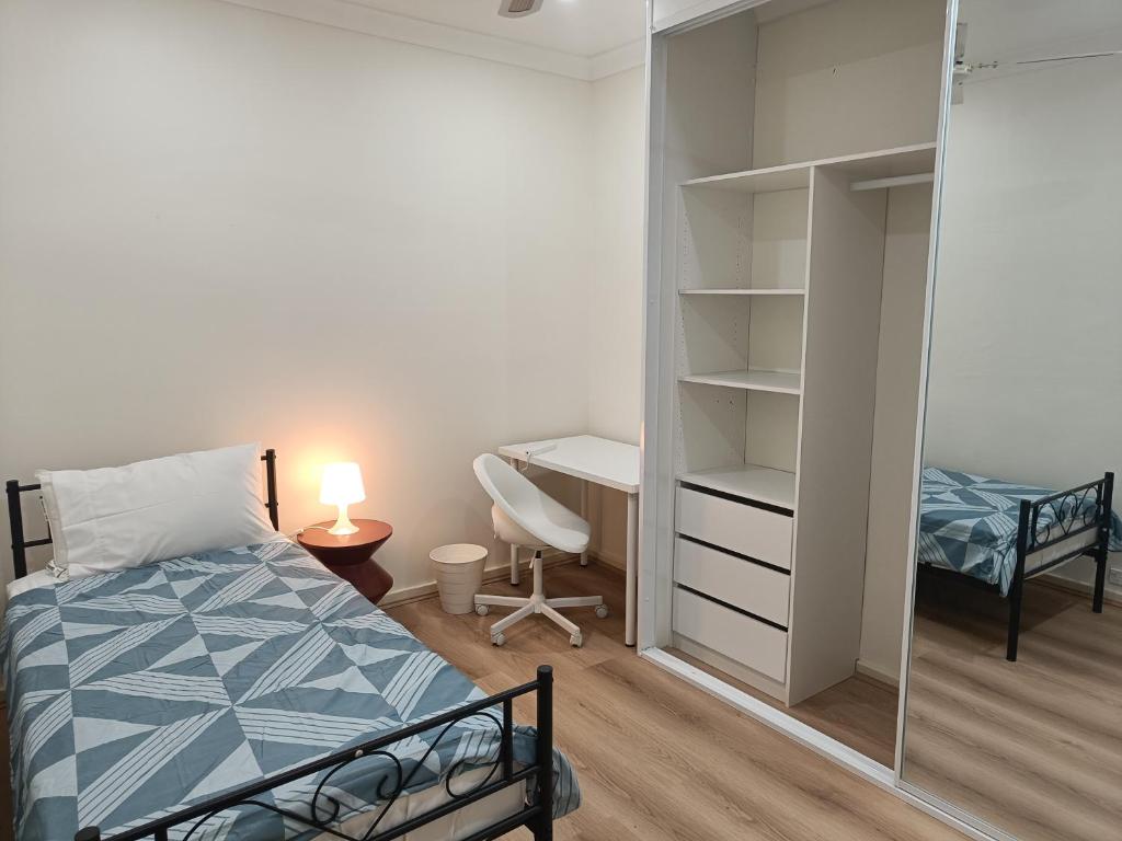 a bedroom with a bed and a desk and a mirror at Comfortable Queen Room - Merrylands - NM4 in Merrylands