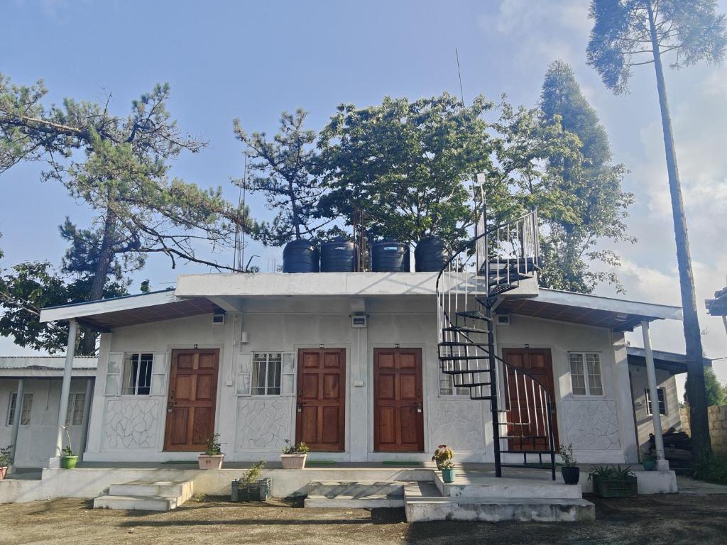 a small white house with red doors and a staircase at Peter and Paul Homestay in Shillong