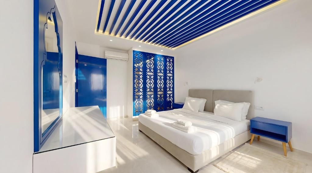 a bedroom with a white bed and a blue ceiling at Seven Floors in Tunis