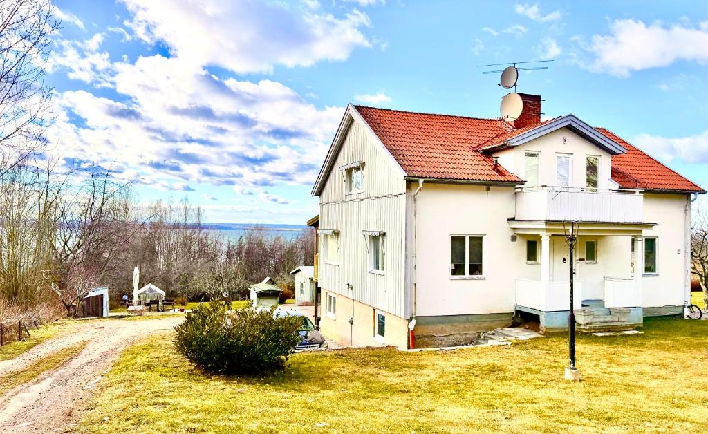 an old white house with a red roof at Charmigt in Gränna