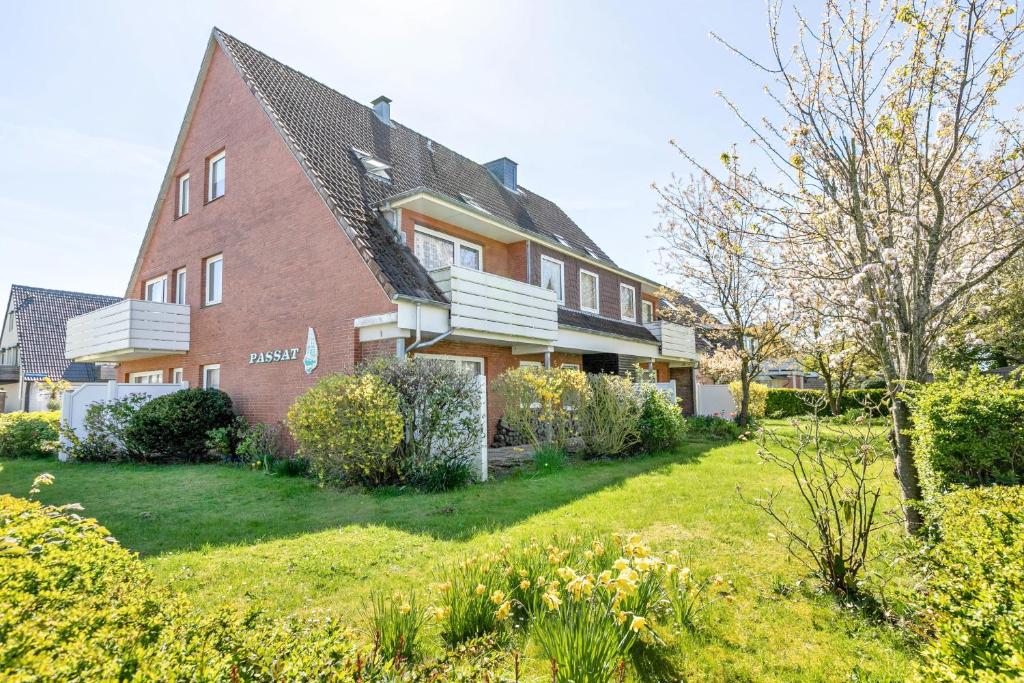 a red brick house with a green yard at Haus Passat in Büsum
