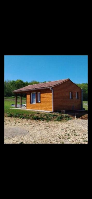 a small wooden house sitting on top of a field at Gîte du Phare in Lanquais