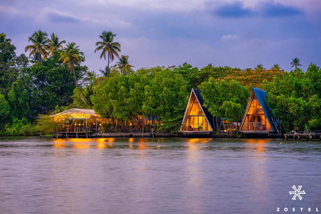 a view of a river with a restaurant on it at Zostel Kochi, Kumbalangi in Cochin