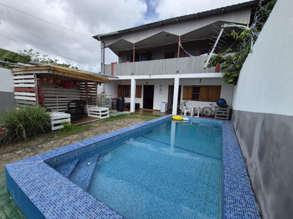 a swimming pool in front of a house at Hostel Sao Gabriel - new pool in São Tomé