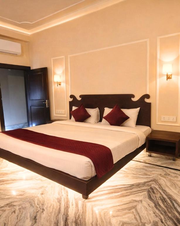 a bedroom with a large bed with red pillows at Laal Haveli Kukas in Jaipur