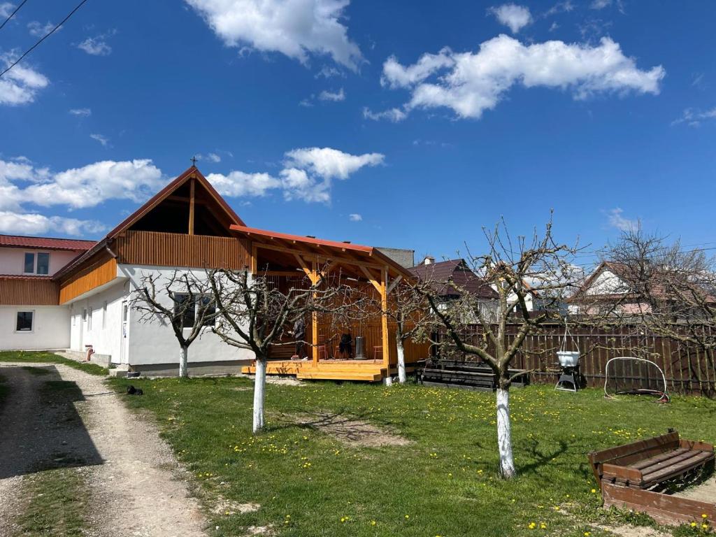 a building with a red roof and some trees at Krausz Chocolate Guesthouse in Sîntimbru