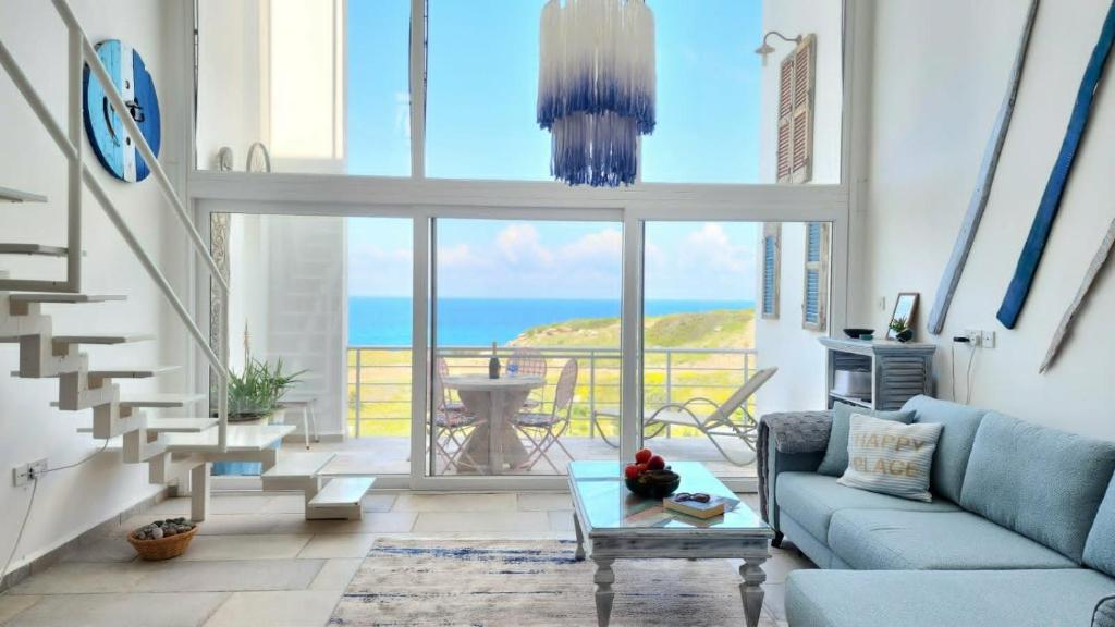 a living room with a blue couch and a view of the ocean at Blue Marine in Kalogrea