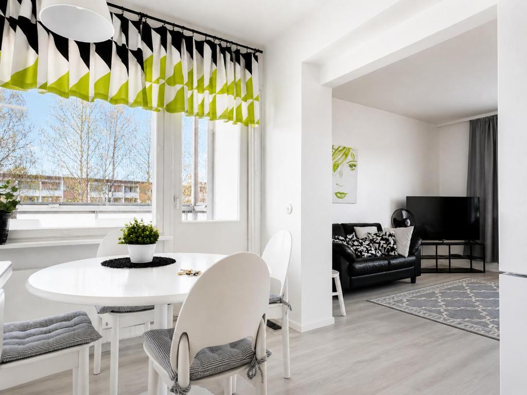 a white dining room with a white table and chairs at Aava's apt. FREE Parking in Pori