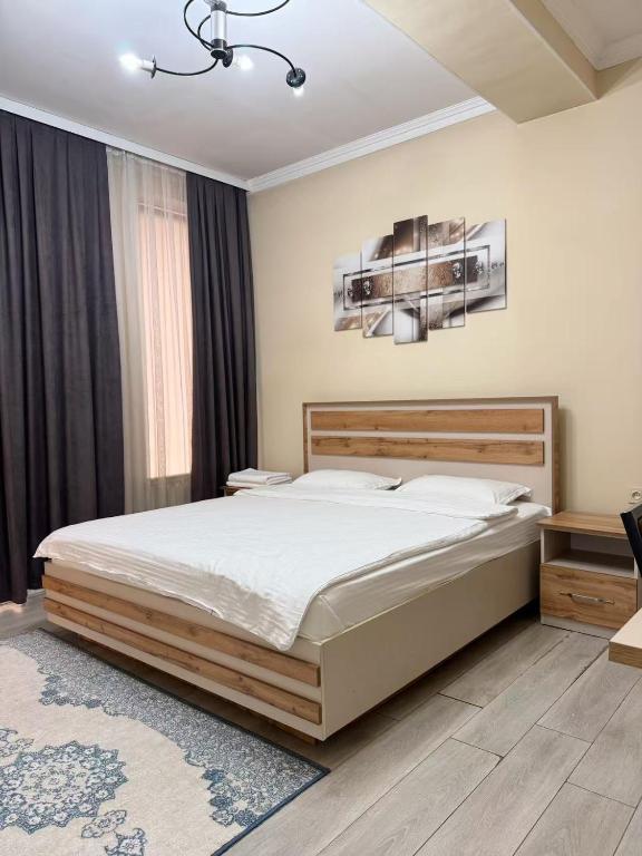 a bedroom with a large bed and a chandelier at Diamond Hotel Даймонд Отель in Var-Kyshtak